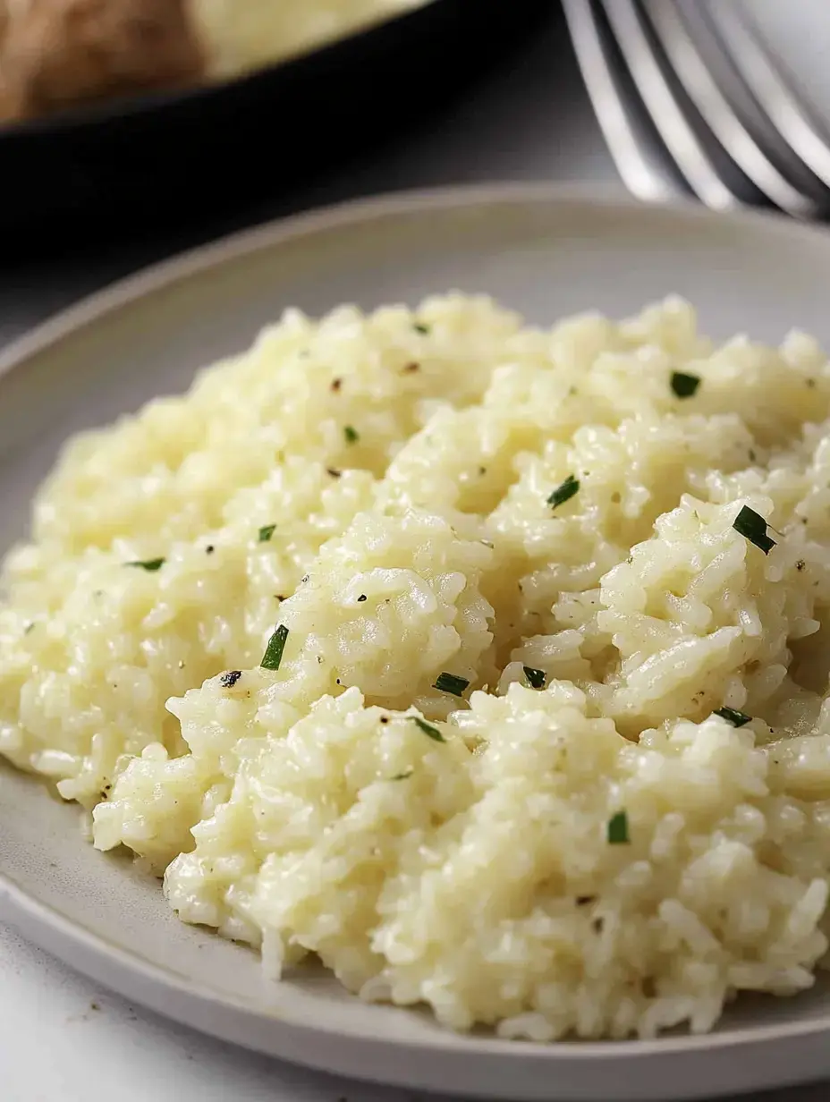 Uma porção de risoto cremoso com ervas num prato claro.