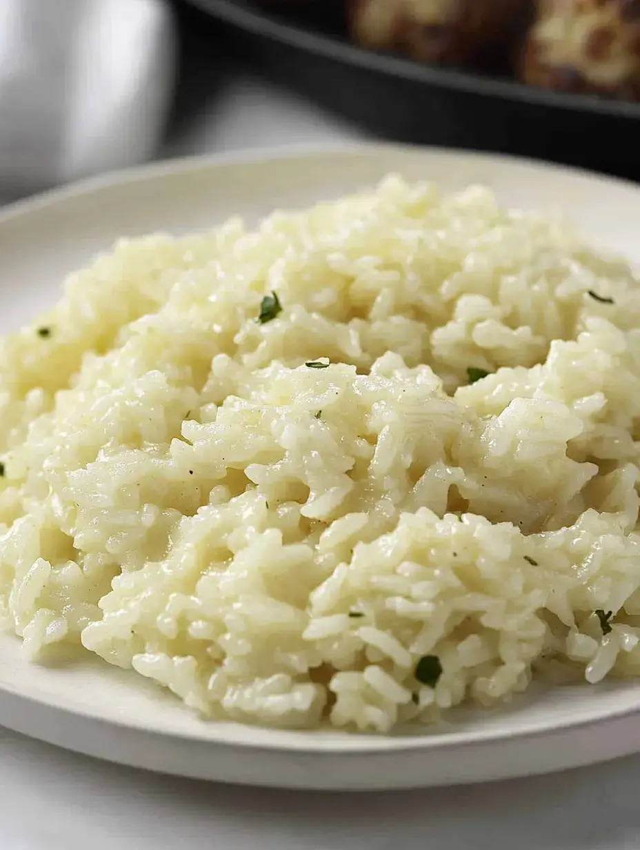 Um prato de arroz cremoso e amanteigado com ervas polvilhadas.